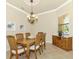 Formal dining room with wood table and chairs, chandelier, and decorative sideboard at 13376 Caravaggio Ct, Venice, FL 34293