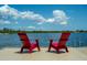 Two red Adirondack chairs on a lakeside dock at 13463 Nobilio St, Venice, FL 34293