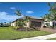 Single-story home exterior, landscaped yard, and brick driveway at 13463 Nobilio St, Venice, FL 34293