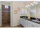 Bathroom featuring a double vanity with a dark countertop, tiled floors, and a walk-in shower at 1537 Monarch Dr, Venice, FL 34293