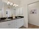 Bright bathroom featuring a double vanity with a dark countertop and white cabinets at 1537 Monarch Dr, Venice, FL 34293