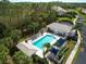 Community pool area with lounge chairs, sun umbrellas, and cabana, surrounded by tropical plants at 1537 Monarch Dr, Venice, FL 34293