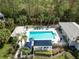 Community pool area with lounge chairs, sun umbrellas, and cabana, surrounded by tropical plants at 1537 Monarch Dr, Venice, FL 34293