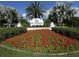 Landscaped entrance to The Plantation Golf & Country Club, featuring colorful red flowers at 1537 Monarch Dr, Venice, FL 34293