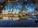 Exterior of a building reflected in a pond with a walking bridge and mature trees at 1537 Monarch Dr, Venice, FL 34293