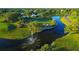 Aerial view of a lush green golf course with a water feature and surrounding trees at 1537 Monarch Dr, Venice, FL 34293