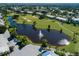 Aerial shot of a golf course with mature trees, water features, and surrounding neighborhood at 1537 Monarch Dr, Venice, FL 34293