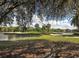 Scenic view of a golf course next to a lake, with trees in the foreground at 1537 Monarch Dr, Venice, FL 34293