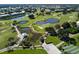 Panoramic aerial view of the golf course with multiple ponds and mature trees at 1537 Monarch Dr, Venice, FL 34293