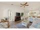 Well-lit living room includes ceiling fan, fireplace, and view to dining area at 1537 Monarch Dr, Venice, FL 34293