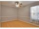 Bedroom with wood-look floors, light gray walls, and window with sheer curtains at 15804 29Th E St, Parrish, FL 34219