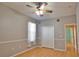 Bedroom with wood-look floors, ceiling fan, closet and window with sheer white curtains at 15804 29Th E St, Parrish, FL 34219