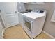 Bright laundry room features a modern washer and dryer set, and neutral tile flooring at 15804 29Th E St, Parrish, FL 34219