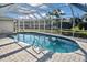 The home's private screened in pool featuring a brick patio and an unobstructed view of the backyard at 1600 Lilliput Ct, Venice, FL 34293