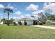 Beautiful home with a well-manicured lawn, palm trees, and driveway at 1600 Lilliput Ct, Venice, FL 34293