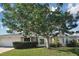 Exterior view of the house featuring a well-maintained lawn and mature trees at 1600 Lilliput Ct, Venice, FL 34293