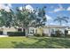 Well-maintained front yard with lush green lawn and mature trees providing shade to the house at 1600 Lilliput Ct, Venice, FL 34293