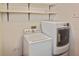 Functional laundry room with a washer, dryer, and ample shelving at 1600 Lilliput Ct, Venice, FL 34293