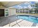 Screened-in private pool with a brick patio and a comfortable spot for relaxation and entertainment at 1600 Lilliput Ct, Venice, FL 34293