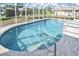 An inviting enclosed pool area with clear blue water and a surrounding screened enclosure at 1600 Lilliput Ct, Venice, FL 34293