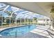 Enclosed pool area featuring clear water, brick patio, and screened enclosure at 1600 Lilliput Ct, Venice, FL 34293