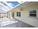 Covered pool patio area features brick pavers, a ceiling fan and access to the home's backyard at 1600 Lilliput Ct, Venice, FL 34293