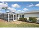 Shot of backyard highlighting home's screened-in pool, lawn, and manicured shrubbery at 1600 Lilliput Ct, Venice, FL 34293