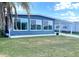 Charming blue home featuring a covered parking area, a well-manicured lawn, and large windows at 17 Nautical Dr, North Port, FL 34287