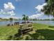 Picturesque lake view with picnic table and benches on the shore, showcasing the community's outdoor amenities at 17 Nautical Dr, North Port, FL 34287