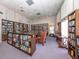 Cozy library featuring wood paneled walls, many shelves of books, and comfortable seating at 17 Nautical Dr, North Port, FL 34287