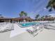 Inviting community swimming pool, lined with sun loungers and palm trees on a bright sunny day at 17 Nautical Dr, North Port, FL 34287