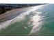 An aerial view of the ocean with surfers enjoying the waves near the beach at 174 Southampton S Pl # 345, Venice, FL 34293