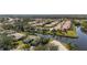 Aerial view of a neighborhood with homes surrounded by landscaping, water features and mature trees at 174 Southampton S Pl # 345, Venice, FL 34293