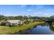 Backyard of a home overlooking a pond, featuring a screened in lanai, mature palms and lush green grass at 174 Southampton S Pl # 345, Venice, FL 34293