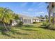 Lush backyard with a screened-in porch, lawn, and tropical foliage perfect for outdoor living at 174 Southampton S Pl # 345, Venice, FL 34293