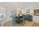 Charming dining area featuring a chandelier, a table with blue chairs, and ample natural light at 174 Southampton S Pl # 345, Venice, FL 34293