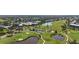 An aerial view of a lush golf course with ponds, sand traps and a view of a neighborhood at 174 Southampton S Pl # 345, Venice, FL 34293