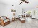 Bright living room featuring wicker furniture, tile floors, and a ceiling fan at 1773 Hudson St, Englewood, FL 34223