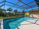 Backyard pool featuring clear blue water, a screened in enclosure, and lush landscaping at 1773 Hudson St, Englewood, FL 34223