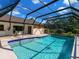 Backyard pool featuring clear blue water and a screened in enclosure at 1773 Hudson St, Englewood, FL 34223