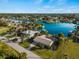 Aerial view of waterfront home with lush landscaping, and a beautiful water view of the canal and boat dock at 18053 Cullman Ave, Port Charlotte, FL 33948