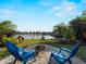 Enjoy the lush backyard with water view, fire pit and relaxing blue Adirondack chairs at 18053 Cullman Ave, Port Charlotte, FL 33948