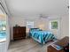 Stylish bedroom featuring wood dresser, a large window view, and vinyl plank flooring at 18053 Cullman Ave, Port Charlotte, FL 33948