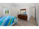 Bright bedroom featuring a wood dresser, ceiling fan, and modern vinyl plank flooring at 18053 Cullman Ave, Port Charlotte, FL 33948