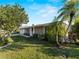 Landscaped front yard with palm trees, grass and home featuring two car garage and neutral exterior at 18053 Cullman Ave, Port Charlotte, FL 33948