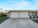 A well maintained two car garage door with beautiful potted plants at the base of the home windows at 18053 Cullman Ave, Port Charlotte, FL 33948