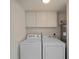 Laundry room with white washer, dryer, and upper cabinets for storage at 18053 Cullman Ave, Port Charlotte, FL 33948