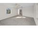 Spacious living room with neutral carpet, window, and a view into the laundry room at 18053 Cullman Ave, Port Charlotte, FL 33948