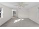 Spacious living room featuring white walls, carpet, and a view into the laundry room at 18053 Cullman Ave, Port Charlotte, FL 33948