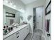 Modern bathroom featuring a white double vanity, decorative lighting, and neutral-toned walls at 19836 Bridgetown Loop, Venice, FL 34293